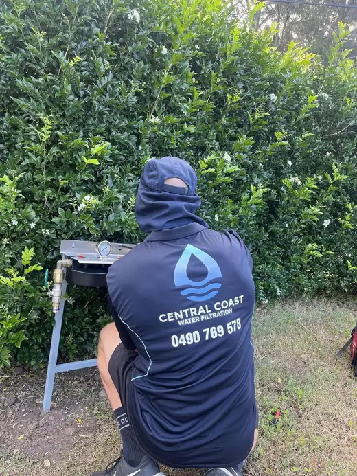 Adam installing a Central Coast Water Filtration system in branded uniform
