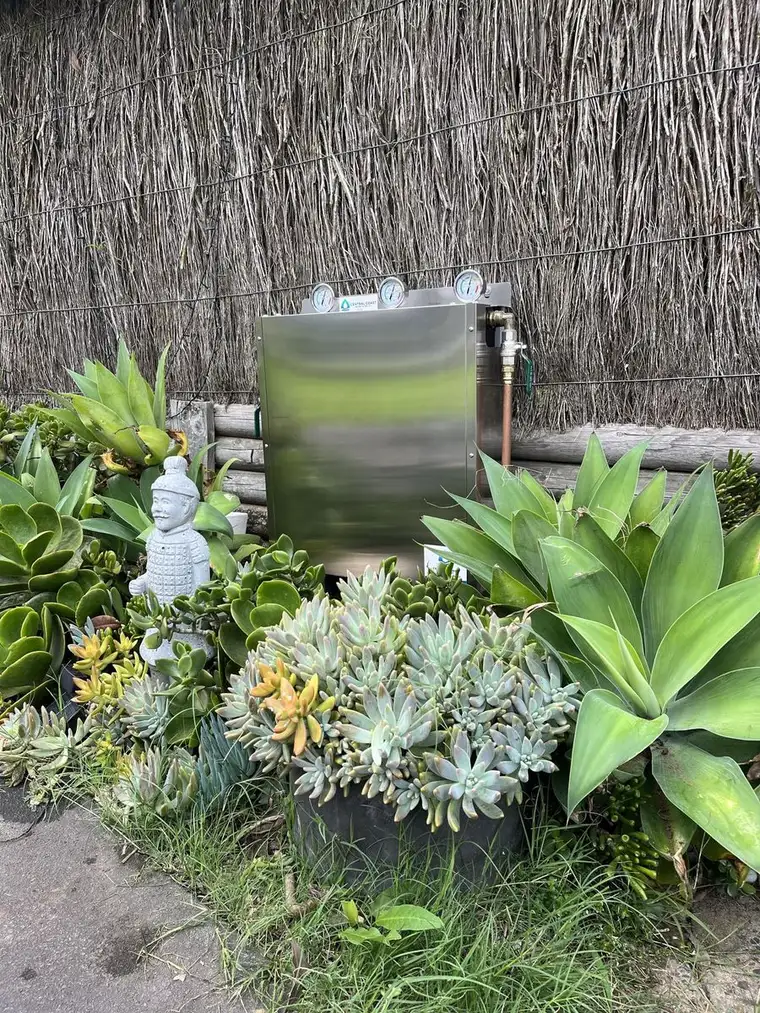 Stainless steel water filtration system installed neatly in a landscaped garden